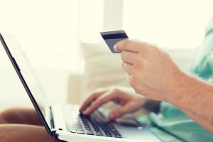 close up of man with laptop and credit card