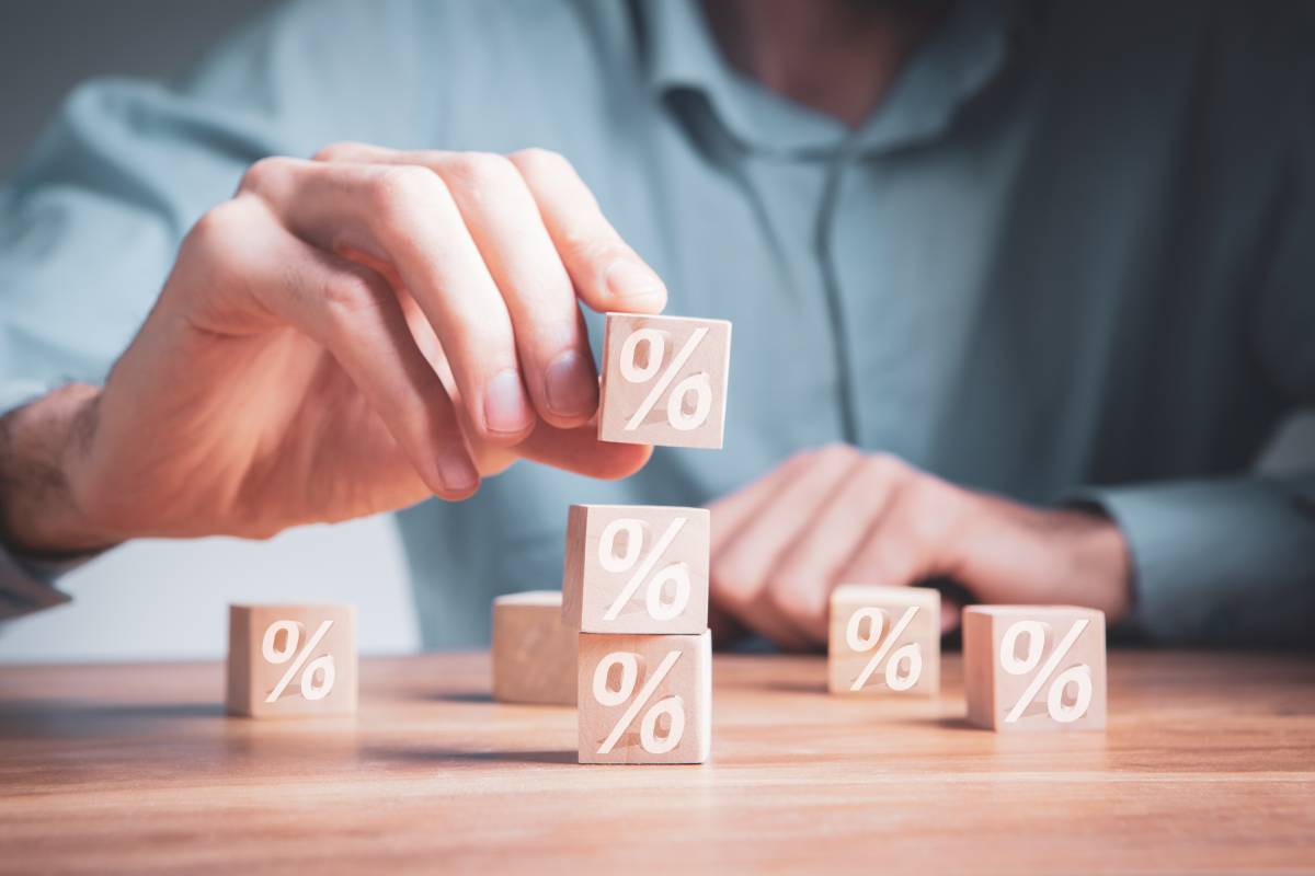 Person stacking wooden blocks with percentage signs written on them