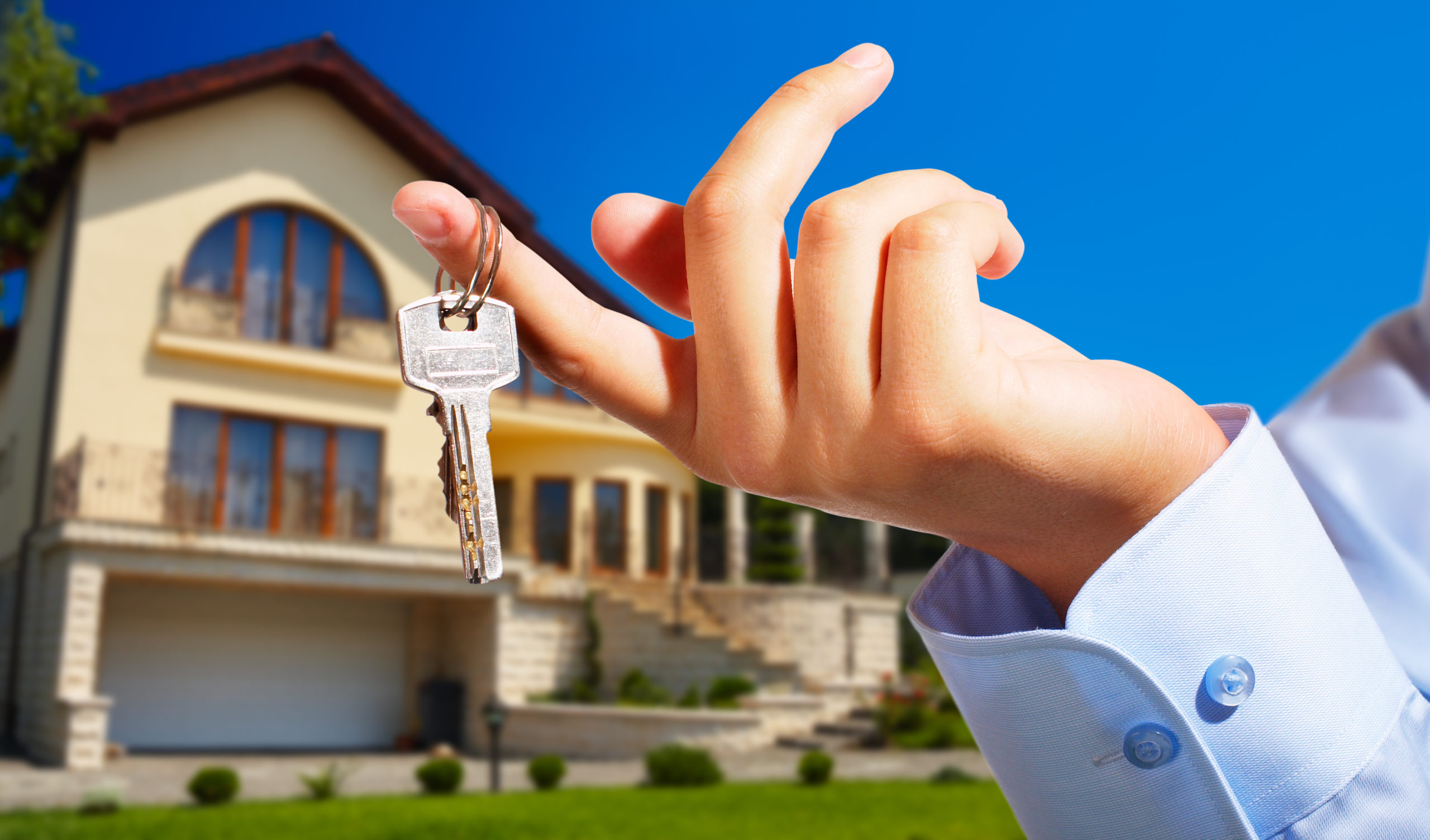 hand holding keys outside of home