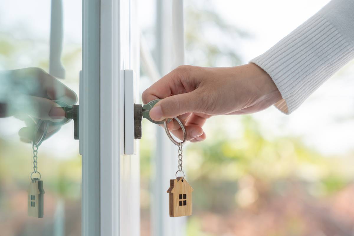 Person unlocking a house door with a key