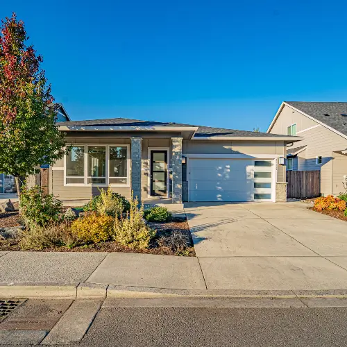 Exterior of a well-maintained, modern single-story rental home with a landscaped yard and garage, professionally overseen by Zenith Properties NW